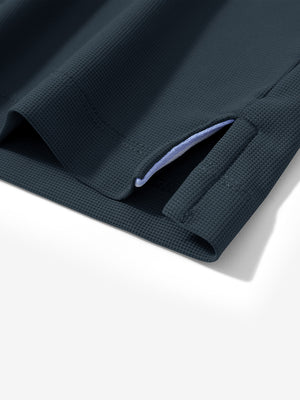 Detail view of hem on dark grey dry fit waffle textured collared golf shirts