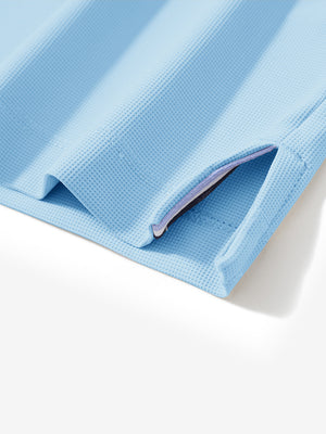 Detail view of hem on light blue dry fit waffle textured collared golf shirts