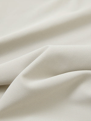 Close-up texture of oyster gray waffle texture 1/4 zip pullover fabric showing detailed waffle knit material and weave.