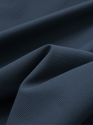 Close-up texture of navy waffle texture 1/4 zip pullover fabric showing detailed waffle knit material and weave.