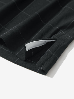 Detail view of hem on rich black grid performance reflective checked collar golf shirt