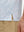 Detail view of hem on grey irregular shape premium ribbed collar print polo shirts