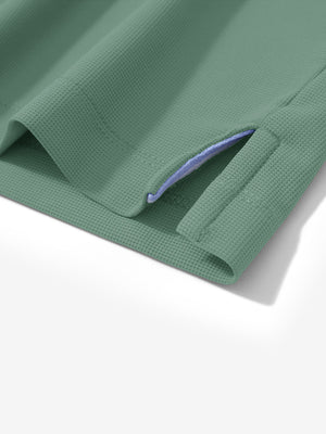 Detail view of hem on green grey dry fit waffle textured collared golf shirts