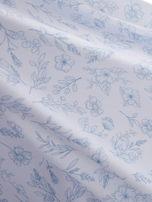 Close-up texture of white blue florals women's sleeveless q-zip print quick dry golf tops fabric showing detailed print and quick dry weave.