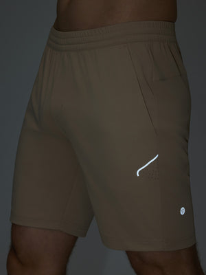 Detail of glow in the dark feature on light khaki 4 way stretch breathable workout athletic shorts
