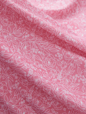 Close-up texture of pink white florals women's sleeveless q-zip print quick dry golf tops fabric showing detailed print and quick dry weave.