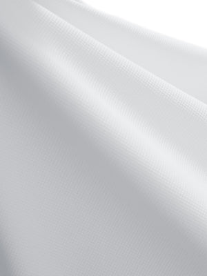 Close-up texture of white dry fit waffle textured collared golf shirts fabric showing weave detail.