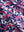 Close-up texture of rose red florals women's sleeveless q-zip print quick dry golf tops fabric showing detailed print and quick dry weave.