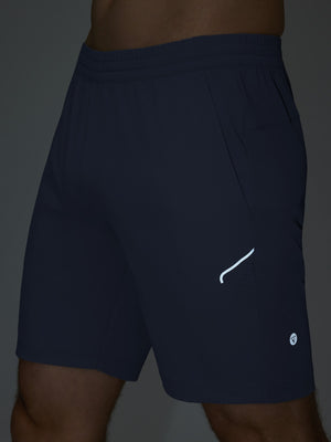 Detail of glow in the dark feature on navy 4 way stretch breathable workout athletic shorts