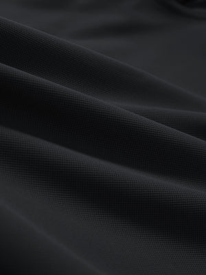 Close-up texture of black dry fit waffle textured collared golf shirts fabric showing weave detail.