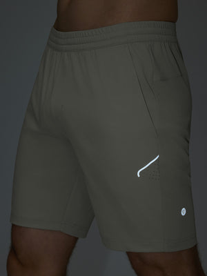 Detail of glow in the dark feature on silver gray 4 way stretch breathable workout athletic shorts