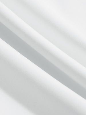 Close-up texture of white women's high waist stretch golf pants with pockets fabric showing weave detail.