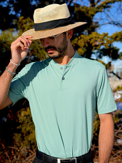 The model is wearing the Everyday Jersey Henley Shirt and is holding his hat with one hand
