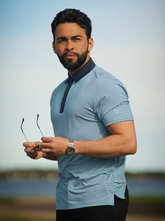 Model wearing the Upgraded Two-tone Striped Quick Dry Polo Shirt, holding a pair of glasses