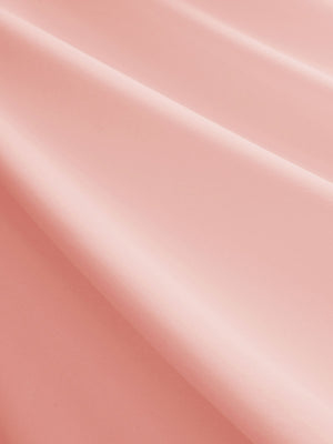 Close-up texture of coral powder women's breathable 1/4 zip pullover golf shirts fabric showing breathable weave detail.