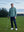 Model leaning on a golf club on course, styled in quarter zip melange pullover with relaxed aqua heather tone